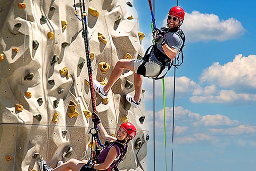 Father and daughter climbing the rock wall together at The EDGE